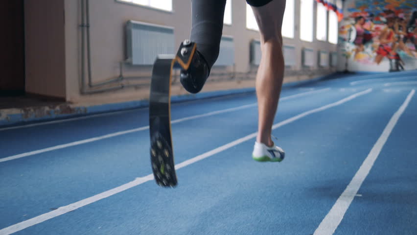 person with prosthesis running on a track, back view. Royalty-Free Stock Footage #1022129998