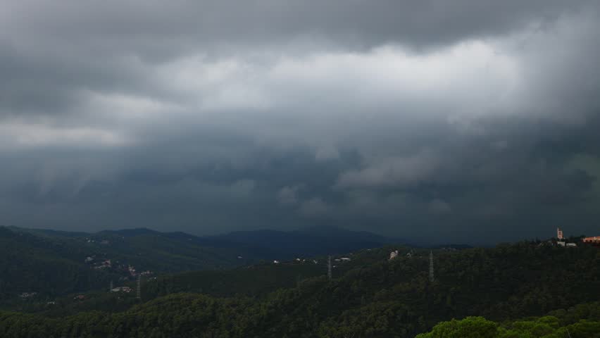 Heavy tunderstorm clouds over green mountains, lightning bolt strike twice at distance and create glowing fire at top of hill. Slow motion shot of rainstorm at Serra de Collserola Royalty-Free Stock Footage #1022146162
