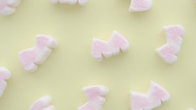 Flat lay or top view of many pink double heart shape marshmallows on yellow background rotating. Cute marshmallows pattern decoration for valentine romantic or happy day.  - Powered by Shutterstock - Get 15% off with code: PIKWIZARD15