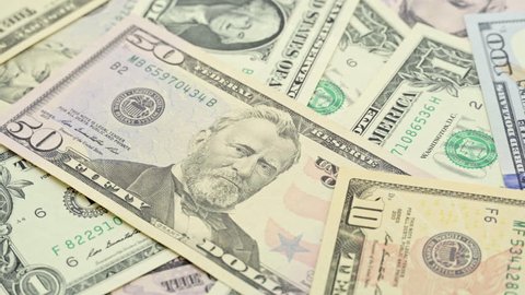 4K footage various price value money cash of US dollars banknotes currency background rotation. A lot of dollars bill closeup rotating. United State of America and world economic financial concept.