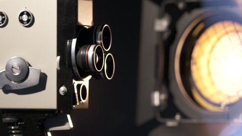 Vintage 8mm film movie camera rotating on black background. Old film camera with triple lens turret and clockwork mechanical motor. Made in USSR 1967-1975. Close-up dolly shot.