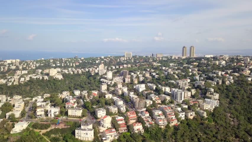 Aerial footage of the city of Haifa, Israel above and over the slopes of Mount Carmel.