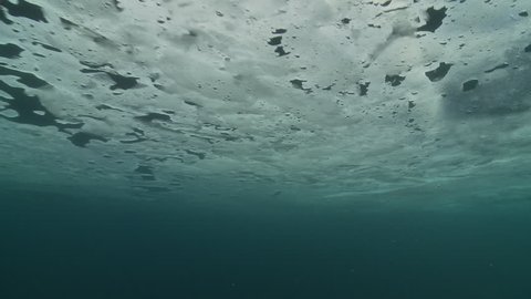 Underwater shot of the ice floe, seen from below, and the depths of the Arctic Ocean