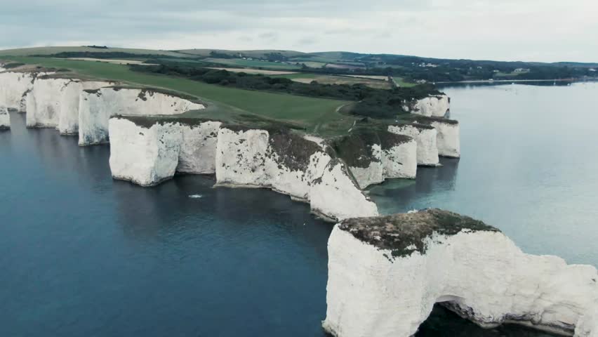 4K - Aerial Footage of Old Harry Rocks - England - Sunrise - Drone Revealing the land.