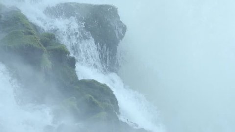 Power of water hitting rocks in a waterfall