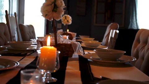 Fancy dinner settings in candlelit home dining room, Panning