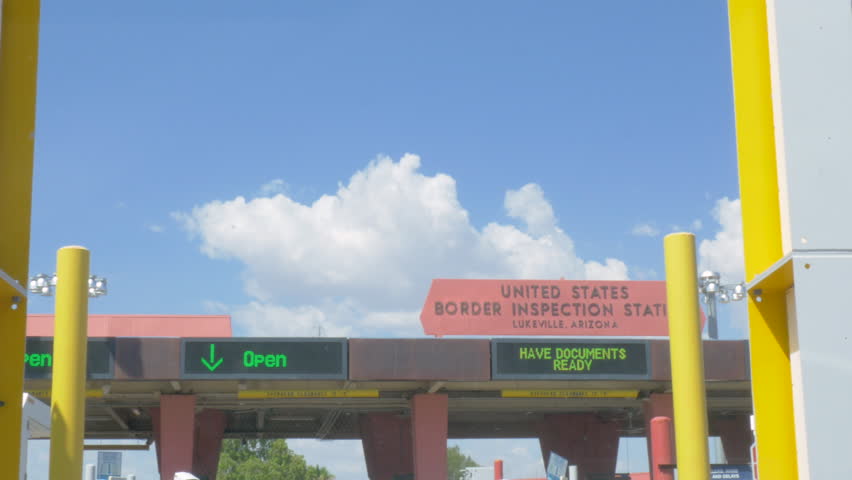 Driving across the border between US and Mexico. Low angle of the inspection station separating the Mexican and American border town of Lukeville, Arizona. Wide shot represents hope for migrants.