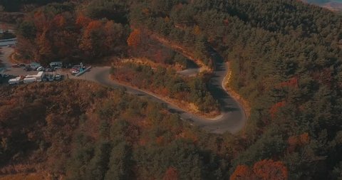 Wide Aerial Tilting Drone Shot of a Race Track in Autumn with a Beautiful Mountain Landscape as a Backdrop.