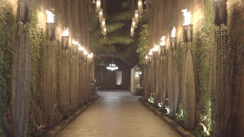 Torches lit on a long hotel hallway