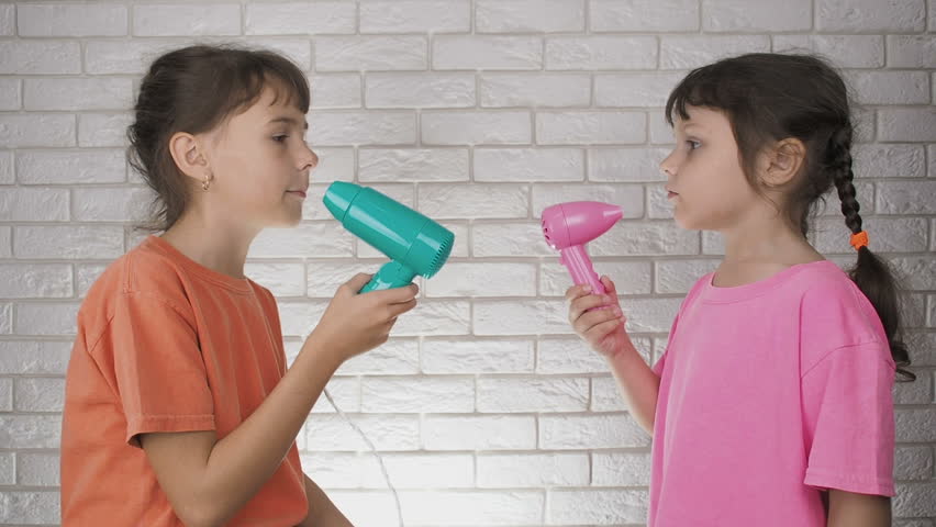 The children are singing. Little girls sing with a hairdryer.