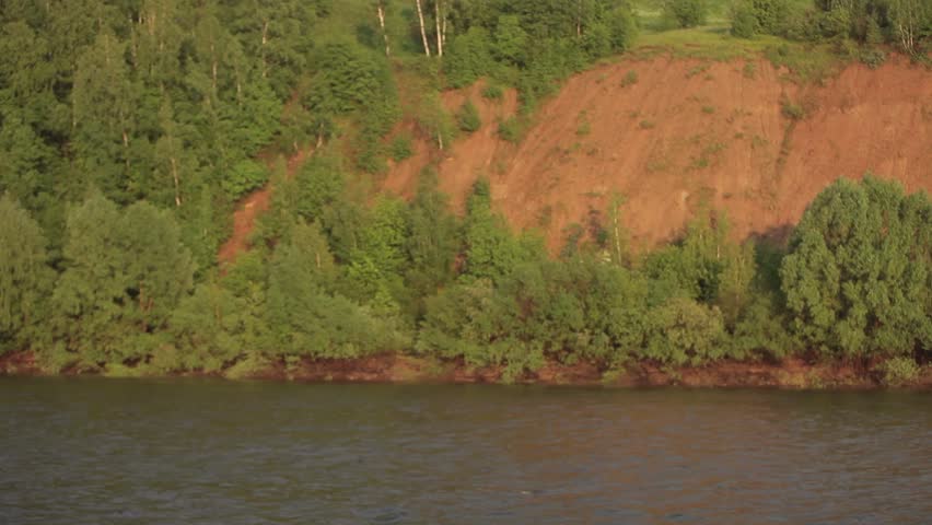 Beautiful view on lake between two mountains on a sunny and bright day. Summer landscape. Sunset forest from boat