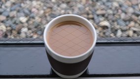 Milk coffee in a mug by the window. Tilt up footage.