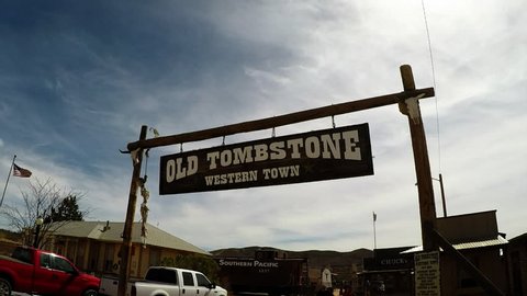 Tombstone, AZ / USA - August 1, 2018: Zoom in shot of the old town sign. An archway entrance sign is seen with cattle skulls and hanging skeletal remains showing the drive in entrance.