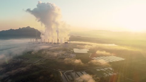  Aerial view of Coal power plant Throwing ash Into the atmosphere during Sunrise. The fog is beautiful.