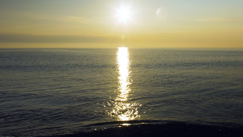 Sun reflecting on the ocean sea by the beach with lens flare part 2