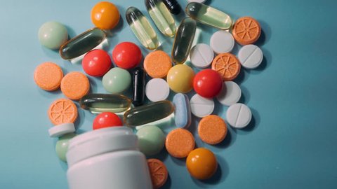 Prescription drugs are spilling from a bottle of pills