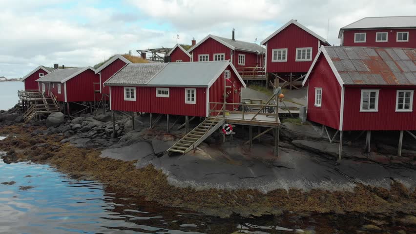 Aerial establishing shot of traditional red wooden houses, Rorbuer in a small fishing  village, Lofoten Islands, Norway.