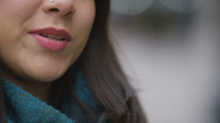 Young Hispanic female talking to someone off camera in the street
