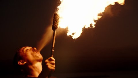 Cool fire show artist breathes fire in dark air, performing amazing stunts - slow motion