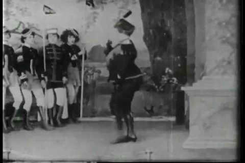 CIRCA 1917 - A man crashes through a set piece, interrupting a burlesque act and amusing the audience.