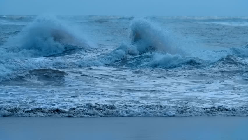 Stormy sea with big blue waves with foam whitecaps and splashes. Large waves in a windy turbulent ocean. Slow mo, slo mo, slow motion, high speed camera, 240fps, 250fps
