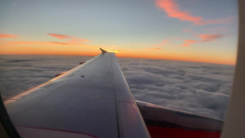 Beautiful View of Sunrise above the clouds from a plane window Royalty-Free Stock Footage #1022239270