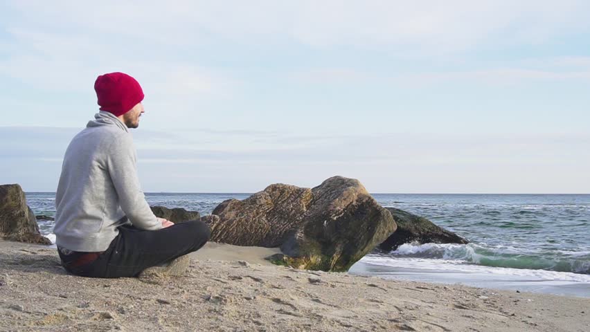 Young male play with corgi dog on the beach in autumn time