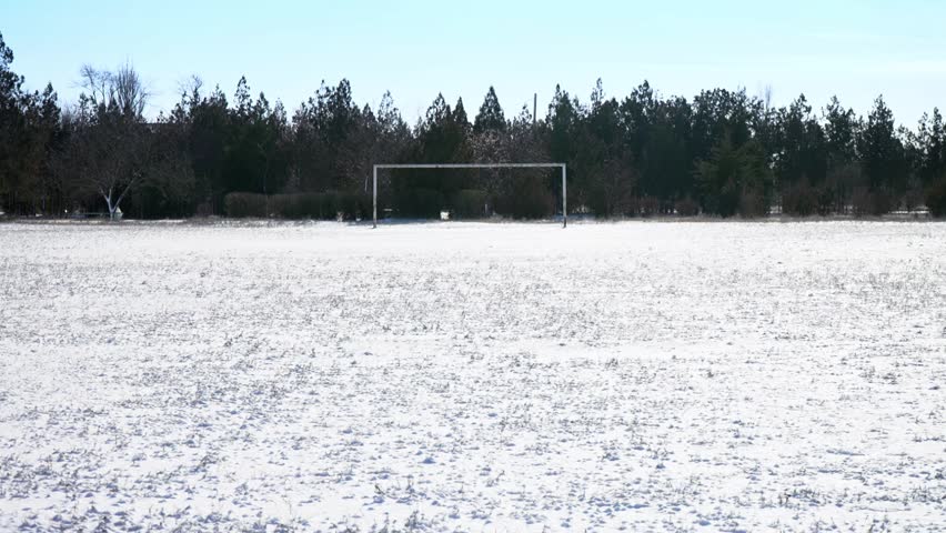 snow on the football field. old football goal. abandoned stadium. off season between championships. Champions League. 