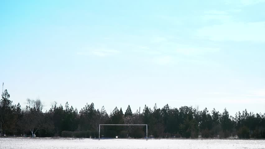 snow on the football field. old football goal. abandoned stadium. off season between championships. Champions League. 