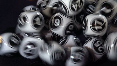 Black and white lottery balls in a bingo machine. Lottery balls in a sphere in motion. Gambling machine and euqipment.