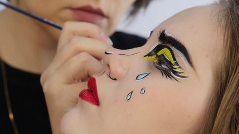Funny cartoon make-up. professional makeup artist doing comic pop art make-up