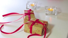 The girl packs a gift, bandages the ribbon on the gift. Romantic atmosphere. HD video