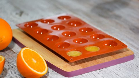 Pouring orange jelly in the silicone mold.