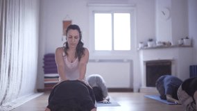 Woman Yoga teacher helping student