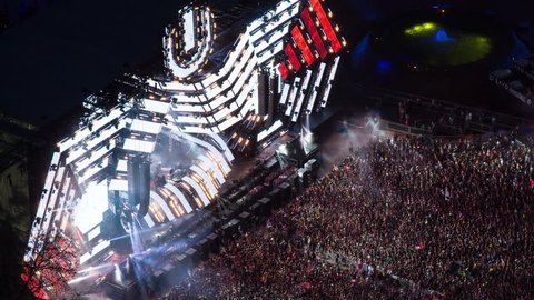 Miami, Florida – Mars 24, 2018: Aerial timelapse of Ultra Music festival concert of electronic songs at night. City downtown, large crowd dancing and scene with light show