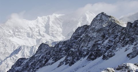 Wide shot POV AERIAL View of K2 Mountain snowcapped cold rocks and mountain peaks in Nepal near Mount Everest in Tibet