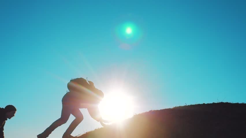 lifestyle teamwork people tourists business travel trip lends a helping hand. two men with backpacks hiking help each other silhouette in mountains with sunlight. slow motion video. teamwork Royalty-Free Stock Footage #1022302720