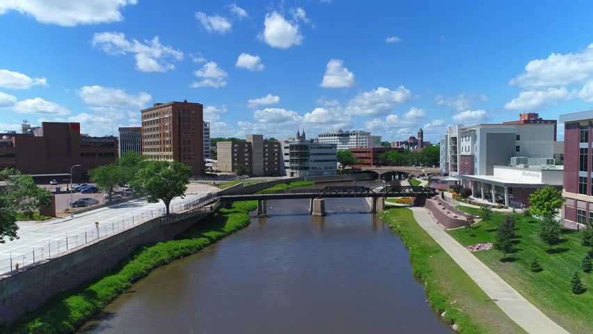 Downtown Sioux Falls, SD over the Big Sioux River with people riding bikes on the bike trail