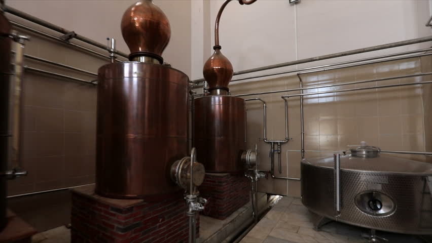 Large stainless steel brandy distilling tanks. Silos for wine and cognac fermentation . Steel barrels for fermentation of wine in winemaker factory . Dolly , ronin movement a long row of spirit vats .