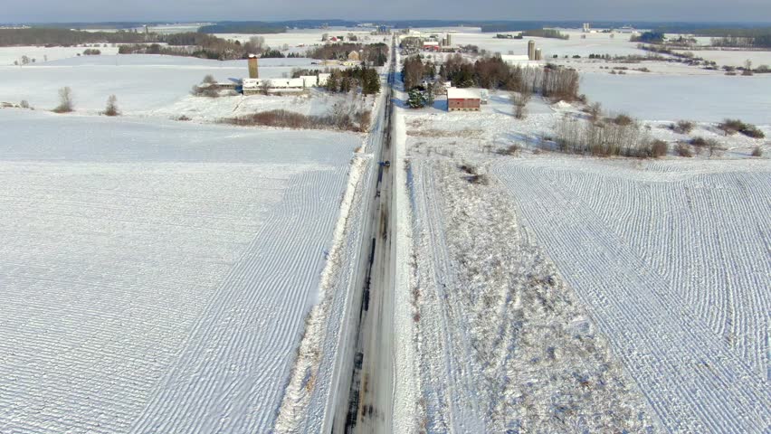 Scenic country road through rural Wisconsin in Winter, aerial flyover.
