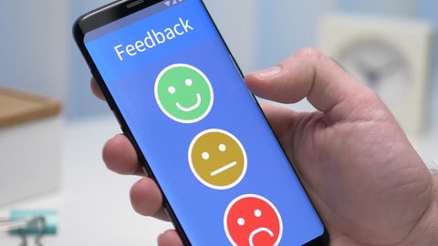 Giving a positive happy face review on a smartphone device. Face ratings concept
