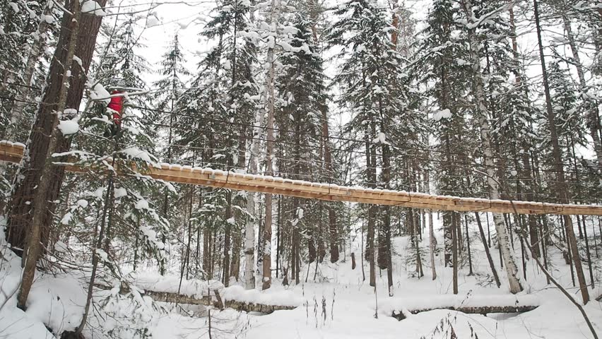 Young Hiking Woman Walking Hanging Bridge National Park In Winter. Rope Hanging Bridge With Wooden Decking Over The Mountain Stream Steadicam Shot.