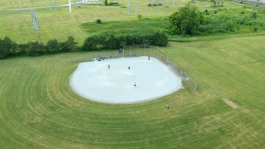 Aerial view of  the baseball diamond field with group of players at summer evening. Green clean baseball sport stadium  bird eye view.  