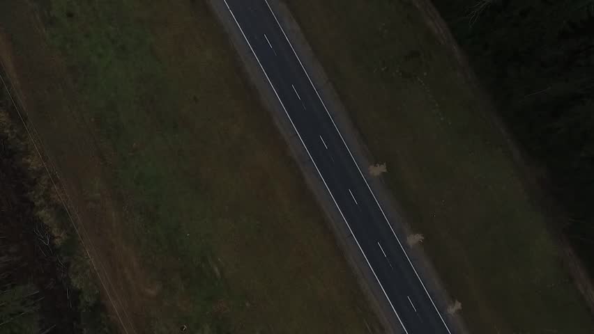 Aerial view of almost empty road it the forest. 2 lanes road.