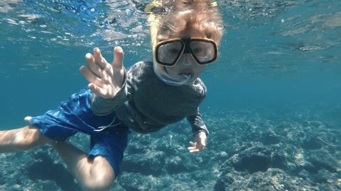 Snorkeling child welcome you to dive with him in clear blue ocean water. Exploring underwater with snorkel, diving mask. Swimming, enjoying adventure in summer vacation