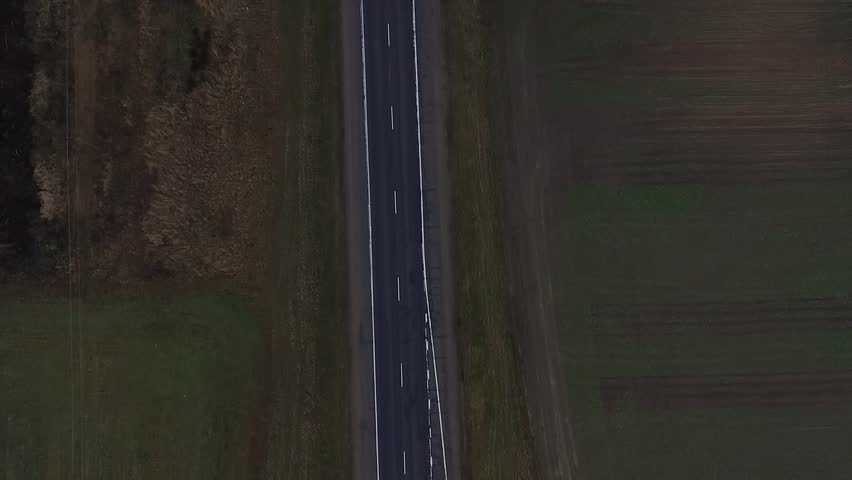 Aerial view of almost empty road it the forest. 2 lanes road.