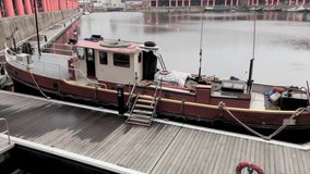 Short tilt up from moored barge to warehouses at the Albert Dock in Liverpool