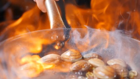 Restaurant concept. Cooking flambe dish. Traditional pasta with Shrimp, Clams, Mussels. Mouth-watering spaghetti with vongole clams. Slow motion. hd