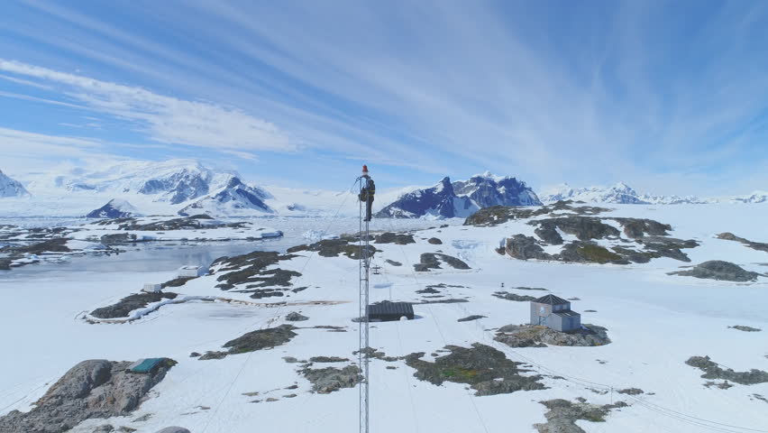 Antarctic Telecom Tower Worker Top Tracking View. Aerial Shot of Telecommunication Engineer Maintenance Cell Signal Antenna. Antarctica Nature and Vernadsky Station Background Drone Footage 4K (UHD)