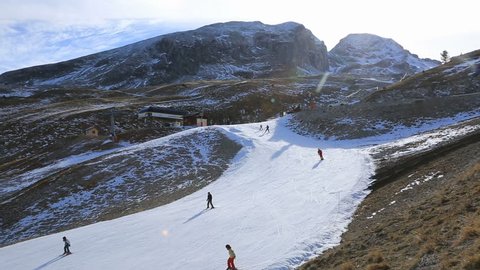 Footage of unidentified people skiing on a slope with artificial snow.